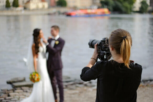 A photographer photographs a bride and groom