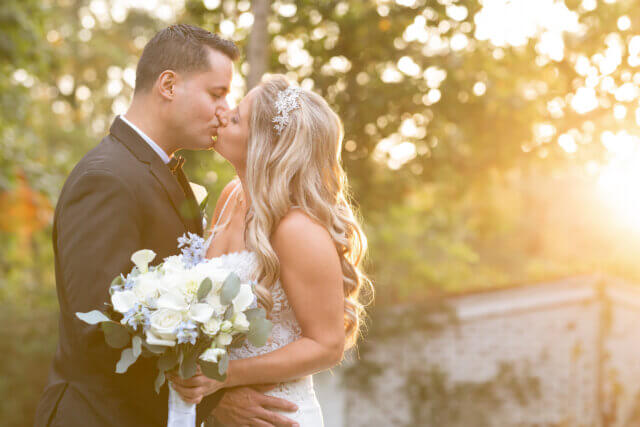 Bride and groom kissing under the sun