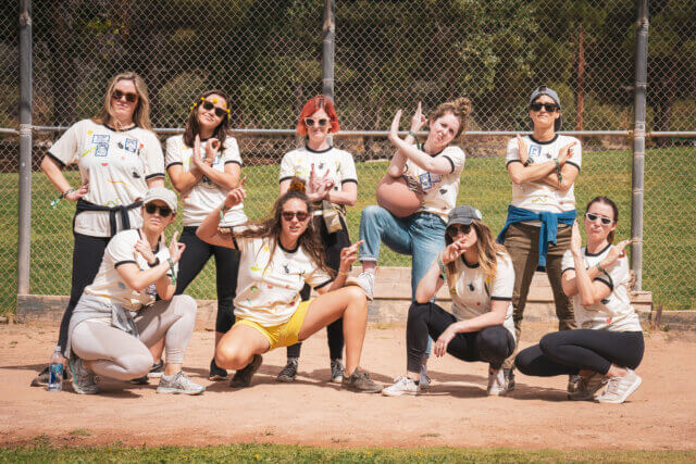 A group of women posing on a baseball field