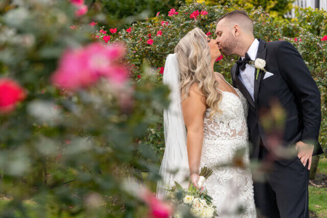 A bride and groom kissing among flowers - Life Art Photographers