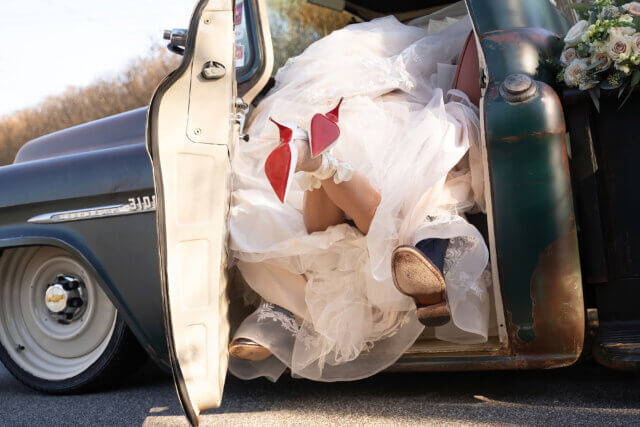 A bride with her feet out of an old truck - Life Art Photographers