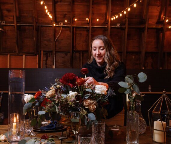 A wedding planner arranges flowers on a table