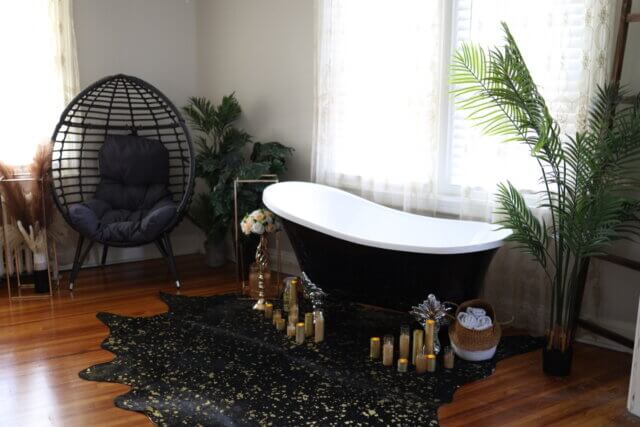 A clawfoot bathtub surrounded by bohemian inspired scenery