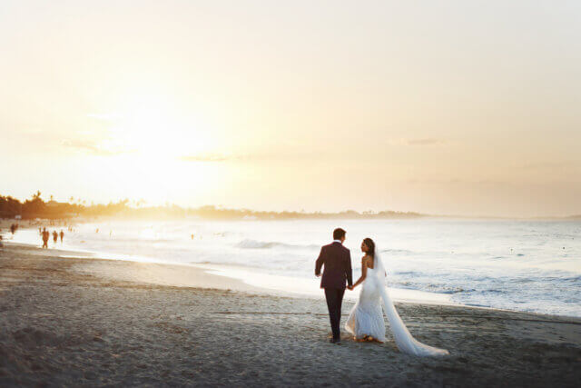 a bride and groom on the beach