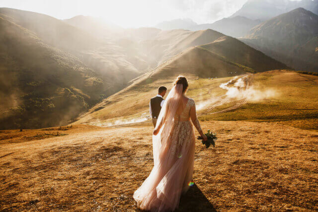 a bride and groom in the mountains