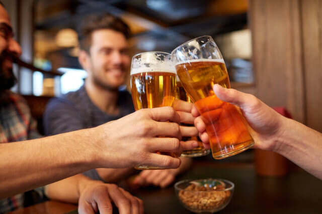 a group of people clinking glasses of beer