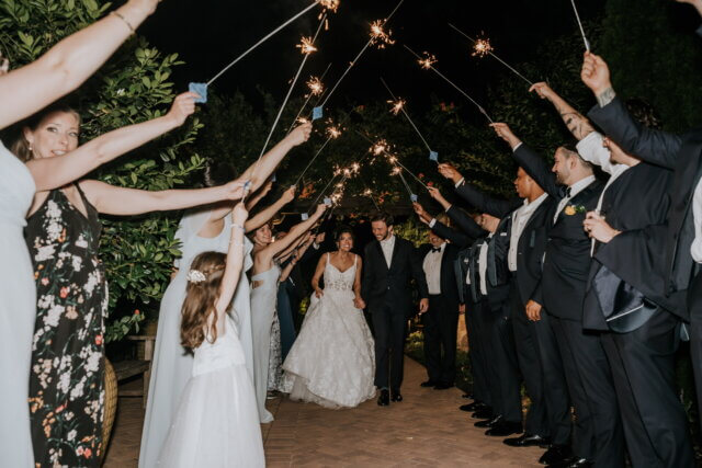 Bride and groom walking through a sparkler arch