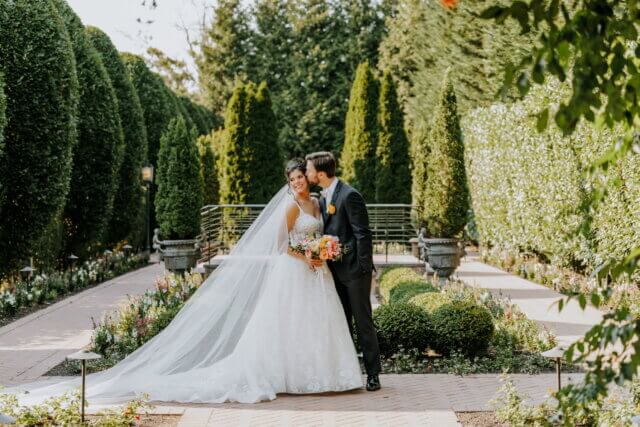 bride and groom kissing in a garden