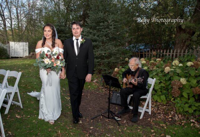 Bride and groom with a guitarist