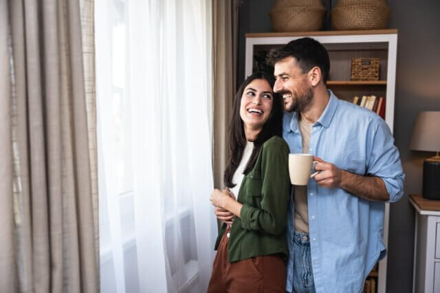 couple smiling looking out a window