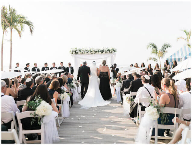Parents giving away a bride at a beach wedding
