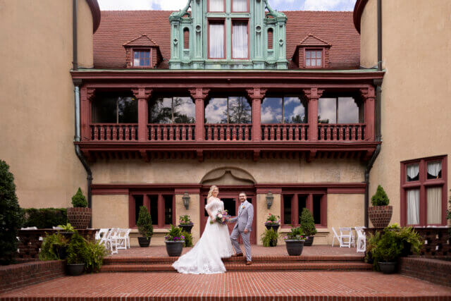 Bride and groom in front of a wedding hall