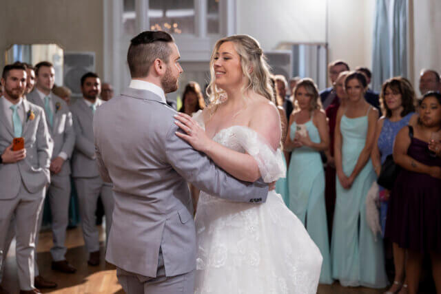 Bride and groom dancing surrounded by their family and friends