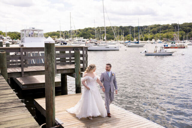 Bride and groom walk along the water