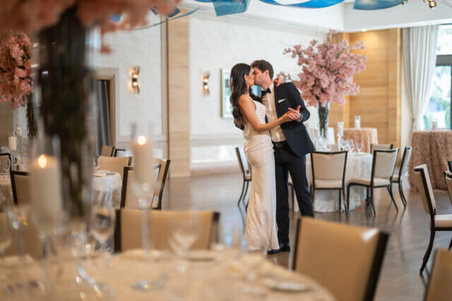 Bride and groom kissing in a dining room